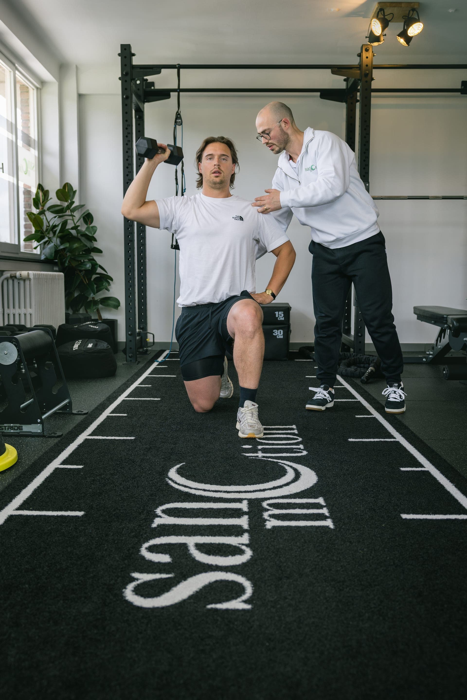 Personal trainer begeleidt een cliënt bij een oefening in de Private Gym